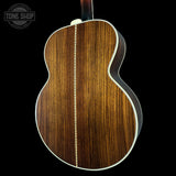 Close-up of a wooden acoustic guitar body with 'Tone Shop' logo.