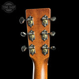Close-up of a guitar headstock with tuning pegs on a black background, featuring the Tone Shop logo.