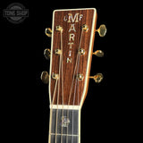 Close-up of a Martin guitar headstock with brand name on a black background