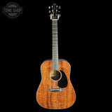 Acoustic guitar with a visible brand logo on a black background