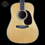 Acoustic guitar with a visible brand logo on a black background