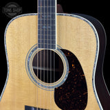 Close-up of an acoustic guitar with a visible brand logo in the corner.