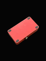 Red electronic device with black components on a textured gray surface