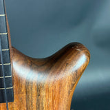 Close-up of a wooden guitar neck against a dark background