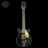 Electric guitar with black and gold design on a white background