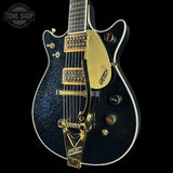 Gretsch electric guitar with gold hardware on a black background