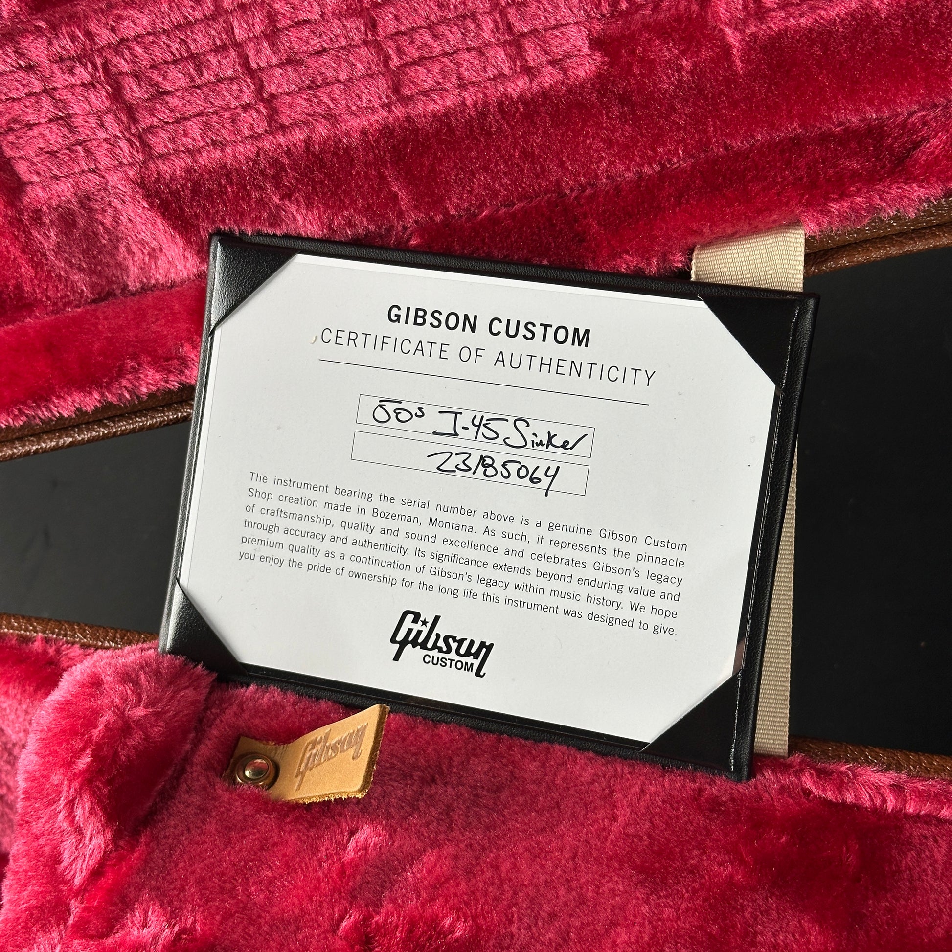 Gibson Custom Certificate of Authenticity on a red textured surface