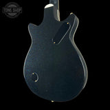 Back view of a black electric guitar with 'Tone Shop' logo in the corner.