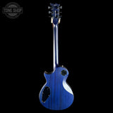 Blue electric guitar on a black background with 'Tone Shop' logo.