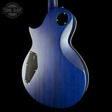Blue electric guitar body with a black pickguard on a black background, featuring 'Tone Shop' logo.