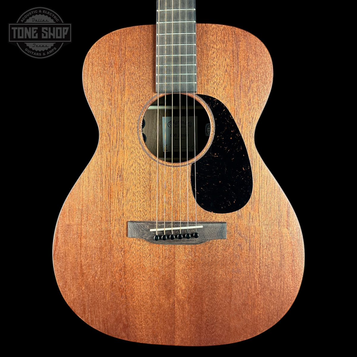 Acoustic guitar with a visible brand logo on a black background