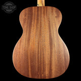Close-up of a wooden acoustic guitar body with 'Tone Shop' logo.