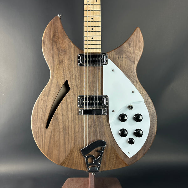 Wooden electric guitar with a white pickguard on a dark background