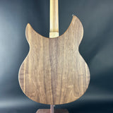 Wooden guitar body on a stand against a dark background