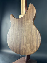 Close-up of a guitar body with a wooden finish on a dark background