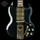 Black electric guitar with gold hardware on a black background, featuring 'Tone Shop' logo.