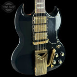 Black electric guitar with gold hardware on a black background, featuring 'Tone Shop' logo.