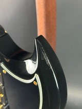 Close-up of a black guitar with a reflective surface