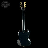 Back view of a black electric guitar with gold hardware on a white background