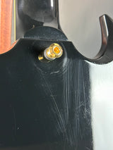 Close-up of a black metal object with a gold screw on a blurred background