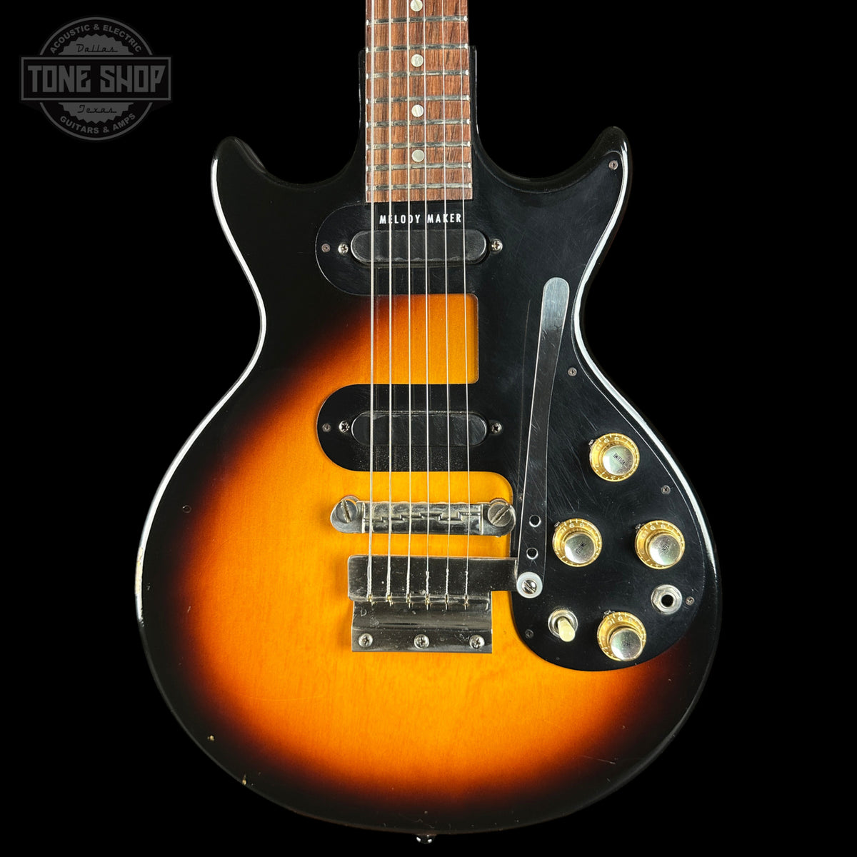 Electric guitar with sunburst finish on a black background, featuring the Tone Shop logo.