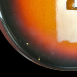 Close-up of a guitar's sunburst finish with a white pickguard.