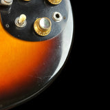 Close-up of a guitar's control panel with sunburst finish