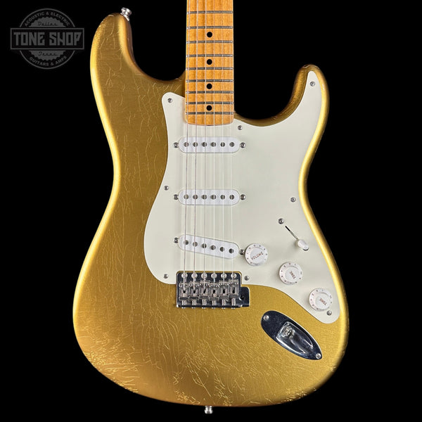 Gold electric guitar with a black background