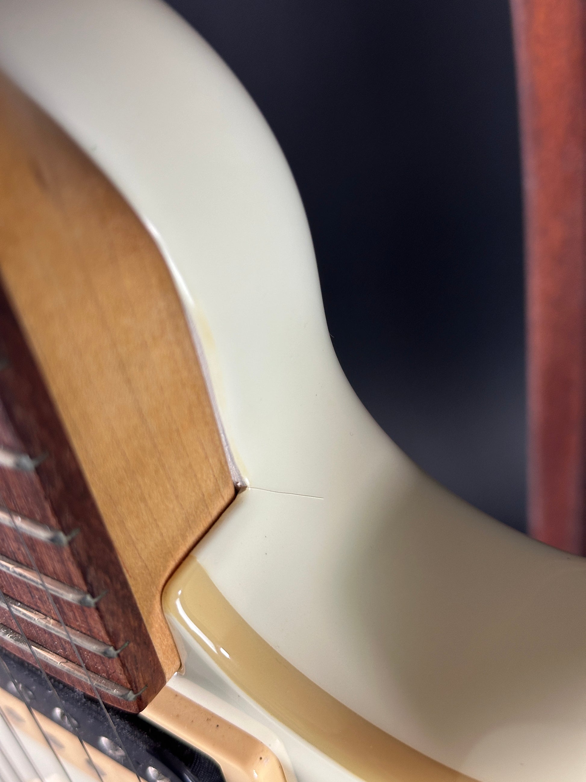 Finish crack at neck joint of Used Ernie Ball Music Man Reflex White.