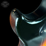 Close-up of a guitar neck with a glossy finish, featuring the Tone Shop logo.
