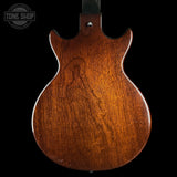 Back view of a wooden guitar body with 'Tone Shop' logo in the corner.