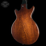 Wooden guitar body with 'Tone Shop' logo in the corner