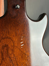 Close-up of a guitar's wooden body with a silver pickguard.