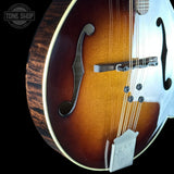 Close-up of a mandolin with a visible brand logo in the corner.