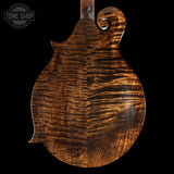 Close-up of a guitar's wooden soundboard with 'Tone Shop' branding.