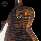 Close-up of a guitar's tortoiseshell pattern with 'Tone Shop' logo.