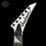 Close-up of a Jackson guitar headstock on a black background