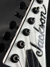 Close-up of a guitar headstock with 'Dean' branding on a black background