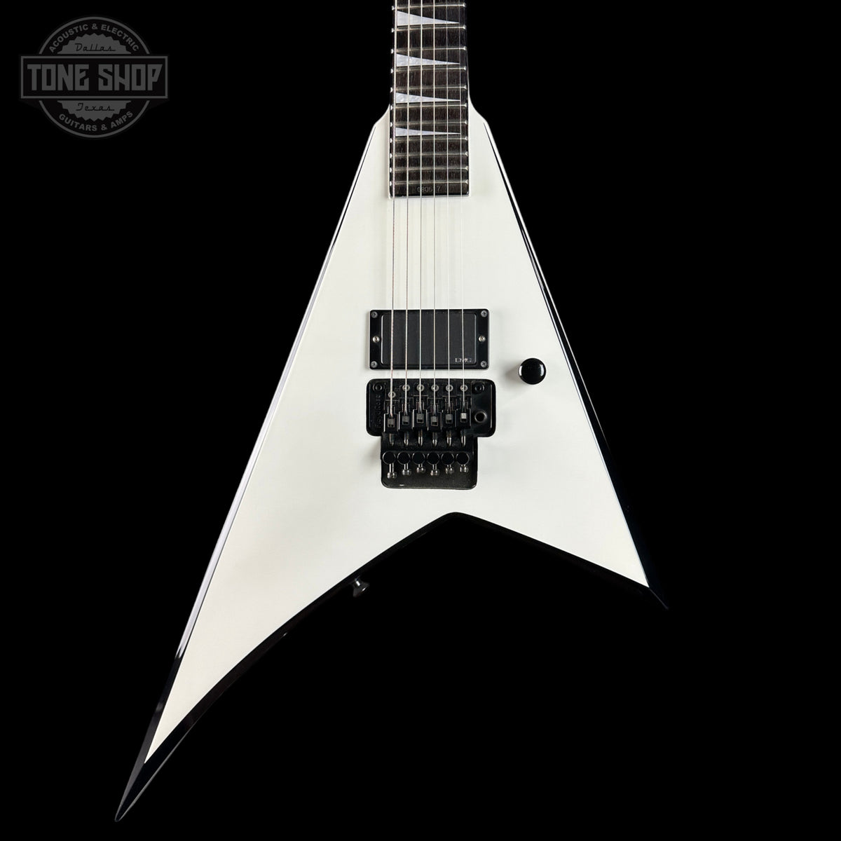 White electric guitar with a black pickguard on a black background, featuring 'Tone Shop' branding.