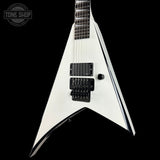 White electric guitar with a black pickguard on a black background, featuring 'Tone Shop' branding.