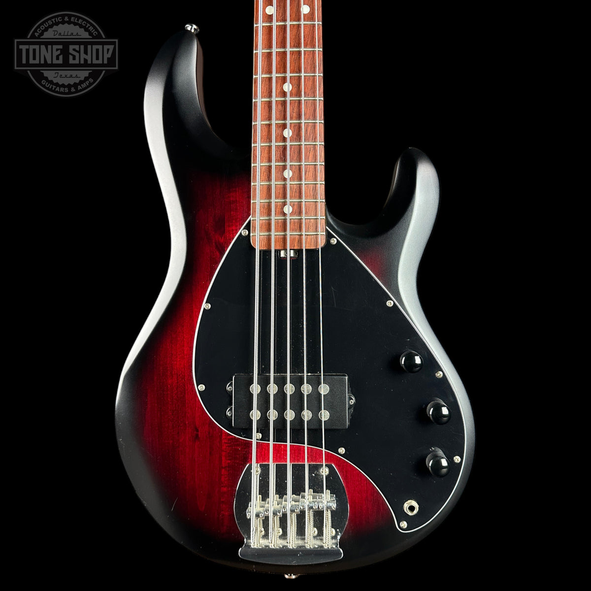 Electric bass guitar with a red and black finish on a black background, featuring the Tone Shop logo.