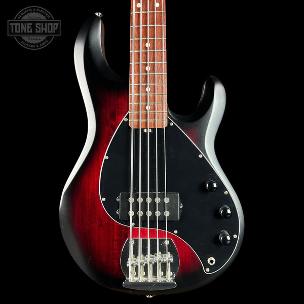 Electric bass guitar with a red and black finish on a black background, featuring the Tone Shop logo.