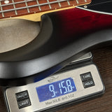 Digital scale displaying weight of a guitar neck on a wooden surface