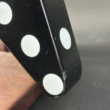 Close-up of a black die with white dots on a blurred background