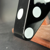 Close-up of a black die with white dots on a gray surface