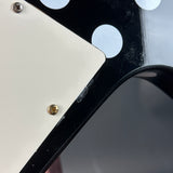 Close-up of a guitar pickguard with screws and polka dot design.
