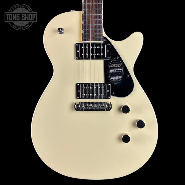 White electric guitar with a black pickguard on a white background