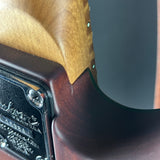 Close-up of a wooden gun stock with a brand logo on a dark background