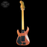 Electric guitar with a wooden body and neck on a black background, featuring the Tone Shop logo.