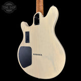 Electric guitar with a white pickguard and brown neck on a black background, featuring 'Tone Shop' branding.